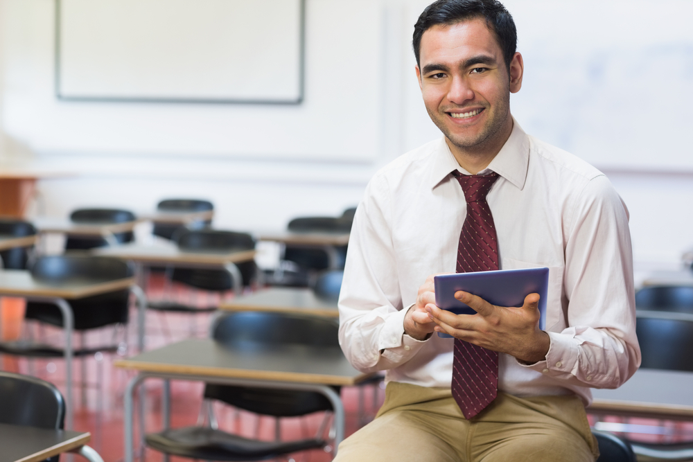 Portrait of a smiling teacher with tablet PC in the class room-1